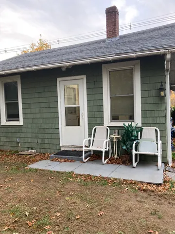 a view of a patio with table and chairs with wooden fence