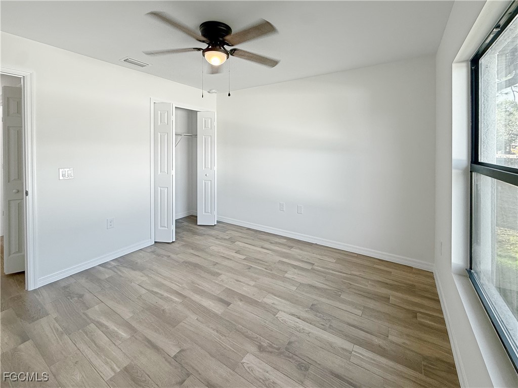 8157 Albatross Road Fort Myers, FL 33967 - Photo 11 of 24 a view of empty room with wooden floor and fan