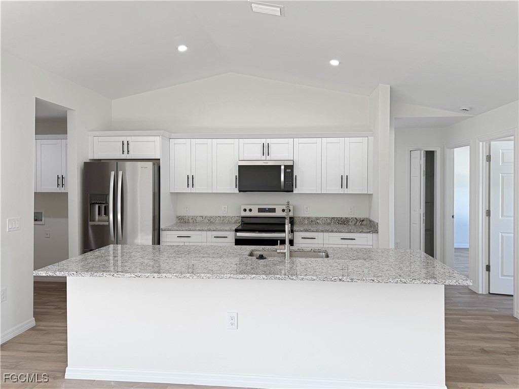 8157 Albatross Road Fort Myers, FL 33967 - Photo 5 of 24 a kitchen with stainless steel appliances granite countertop a refrigerator a stove a sink a microwave and white cabinets