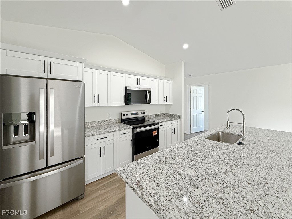 8157 Albatross Road Fort Myers, FL 33967 - Photo 9 of 24 a kitchen with stainless steel appliances granite countertop a refrigerator stove microwave and sink
