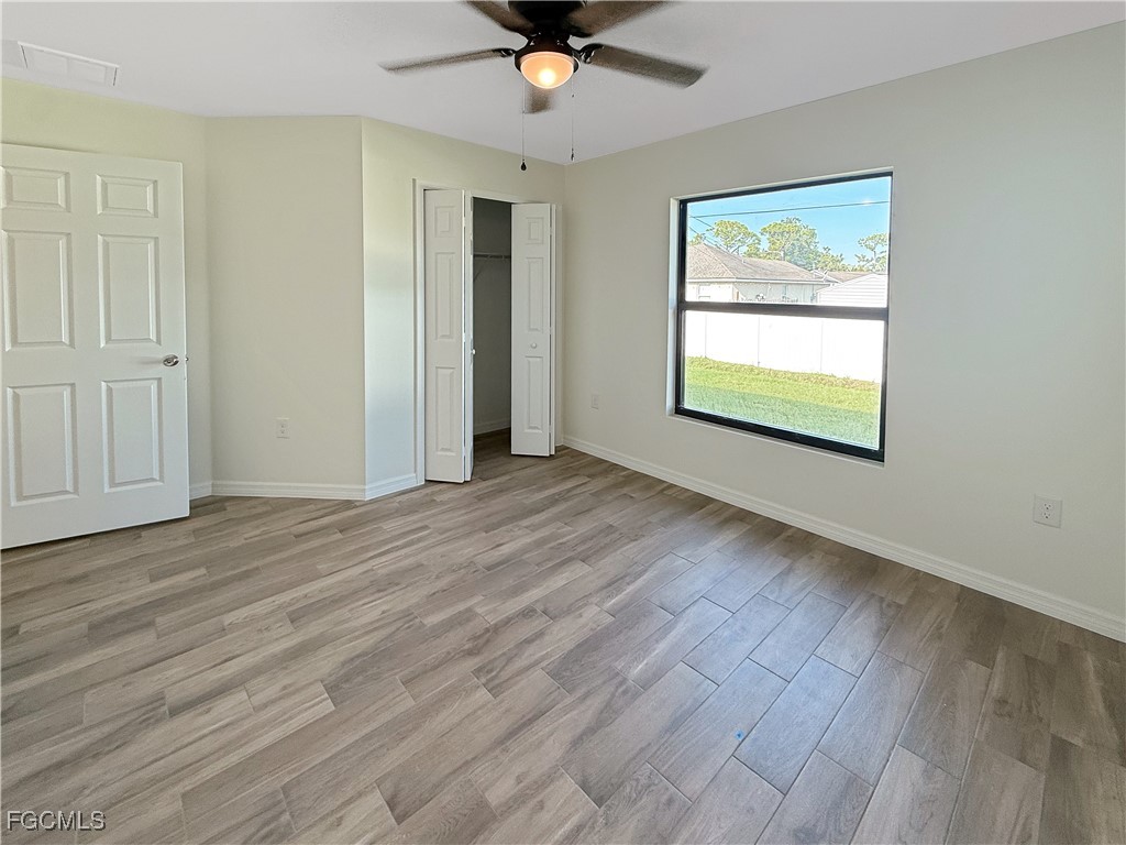 8157 Albatross Road Fort Myers, FL 33967 - Photo 10 of 24 wooden floor in an empty room with a window