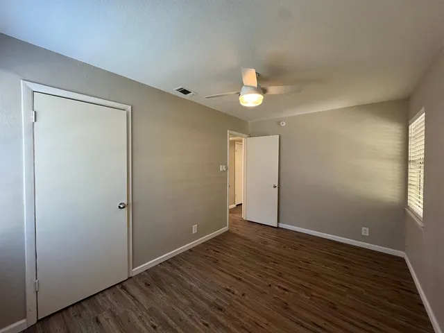 an empty room with wooden floor and window
