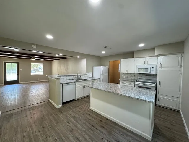 a kitchen with a refrigerator and a stove top oven