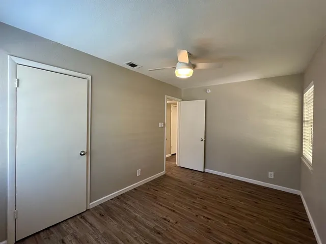 an empty room with wooden floor and window