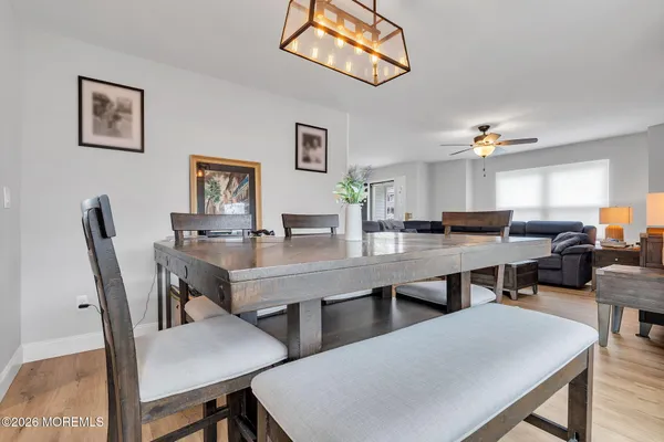 a dining room with wooden floor a table and chairs