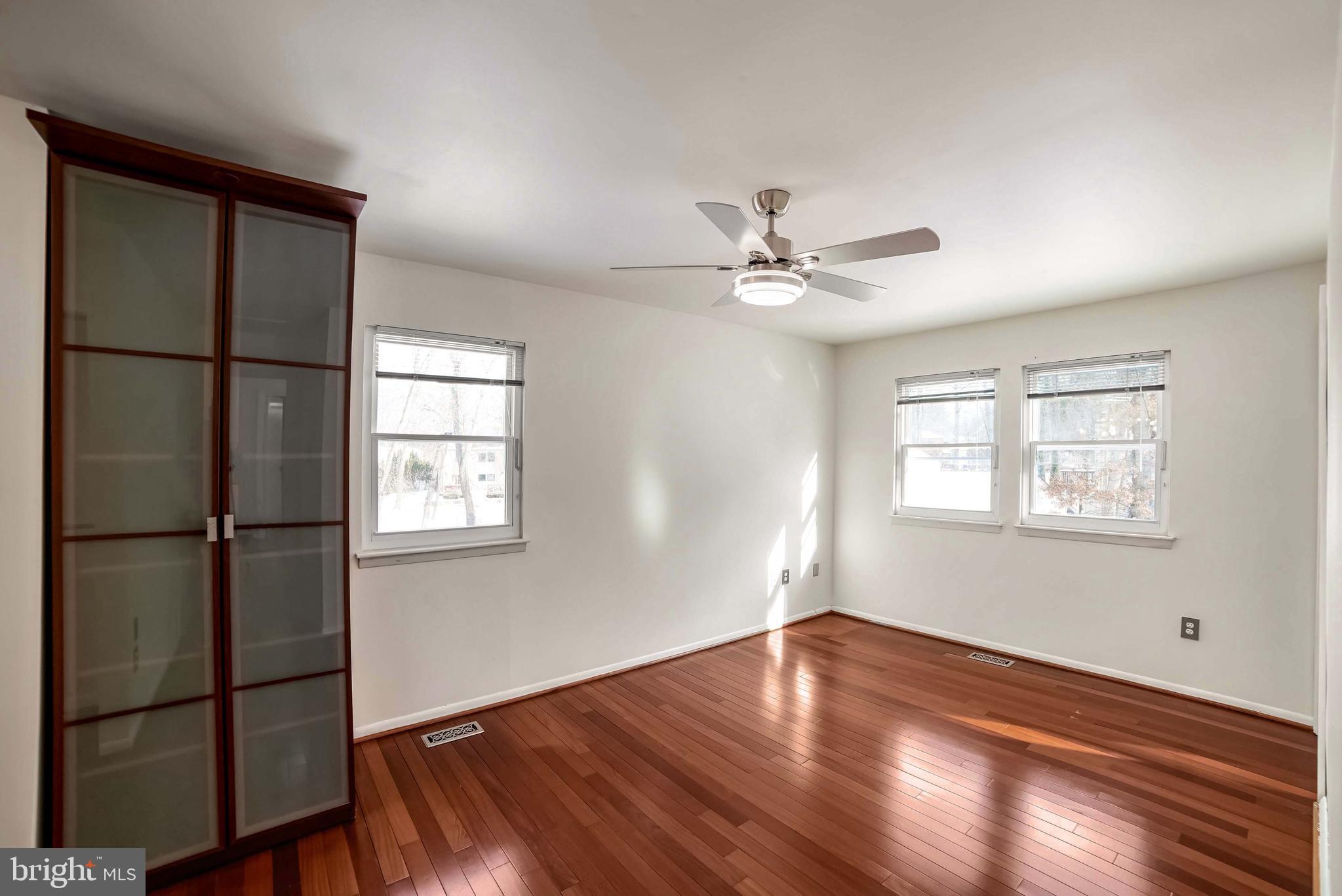 9551 Saddlebag Row Columbia, MD 21045 - Photo 17 of 30 a view of a livingroom with a hardwood floor a ceiling fan and windows