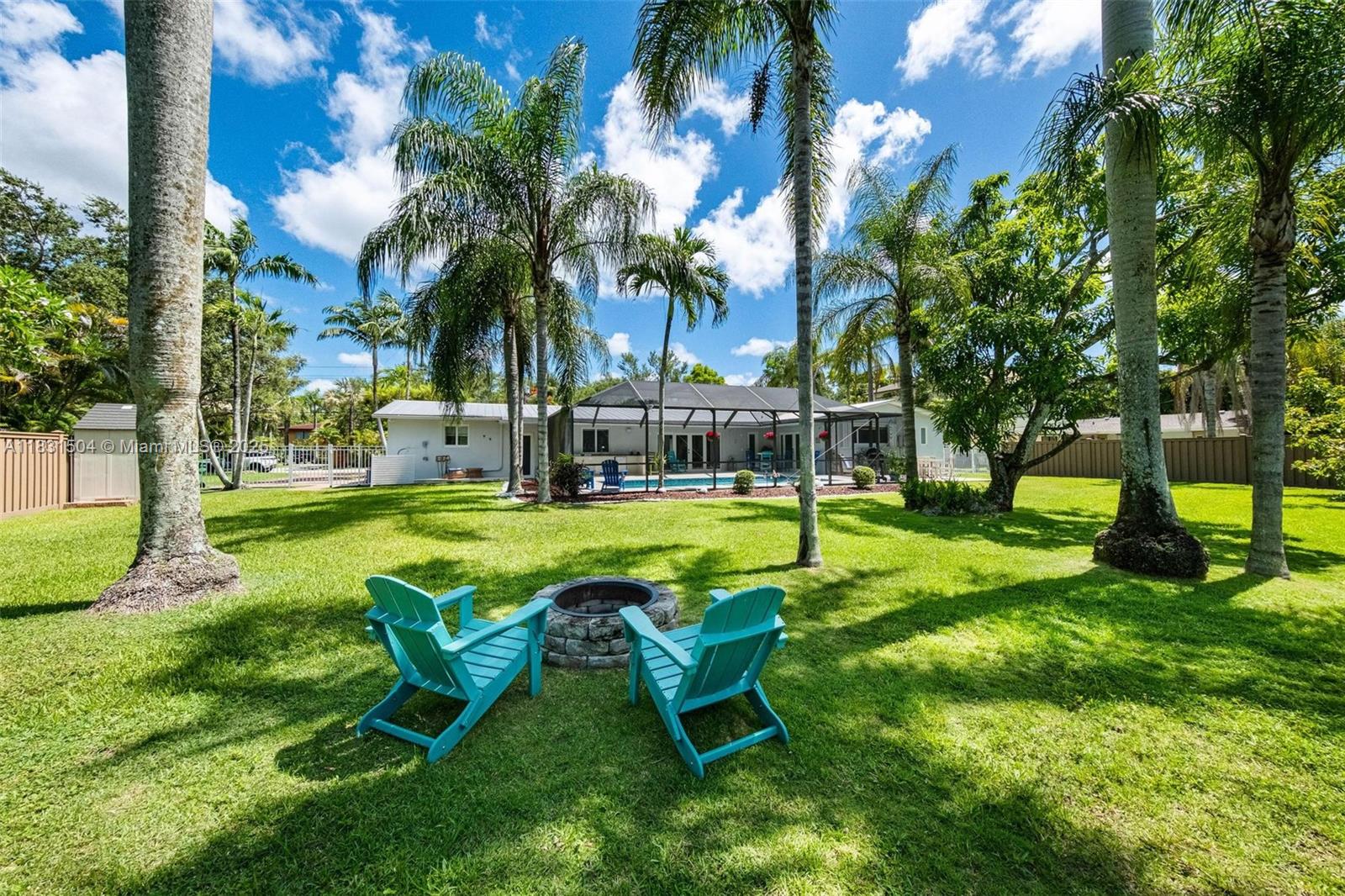 9720 Southwest 140th Street Miami, FL 33176 - Photo 2 of 24 a view of a swimming pool with lawn chairs and a big yard