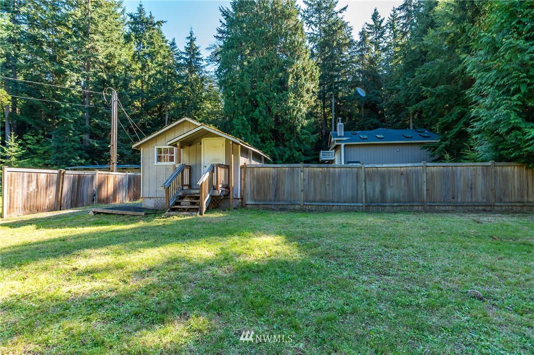 5101 East Harbor Road Freeland, WA 98249 - Photo 22 of 24 a view of a backyard with table and chairs and wooden fence