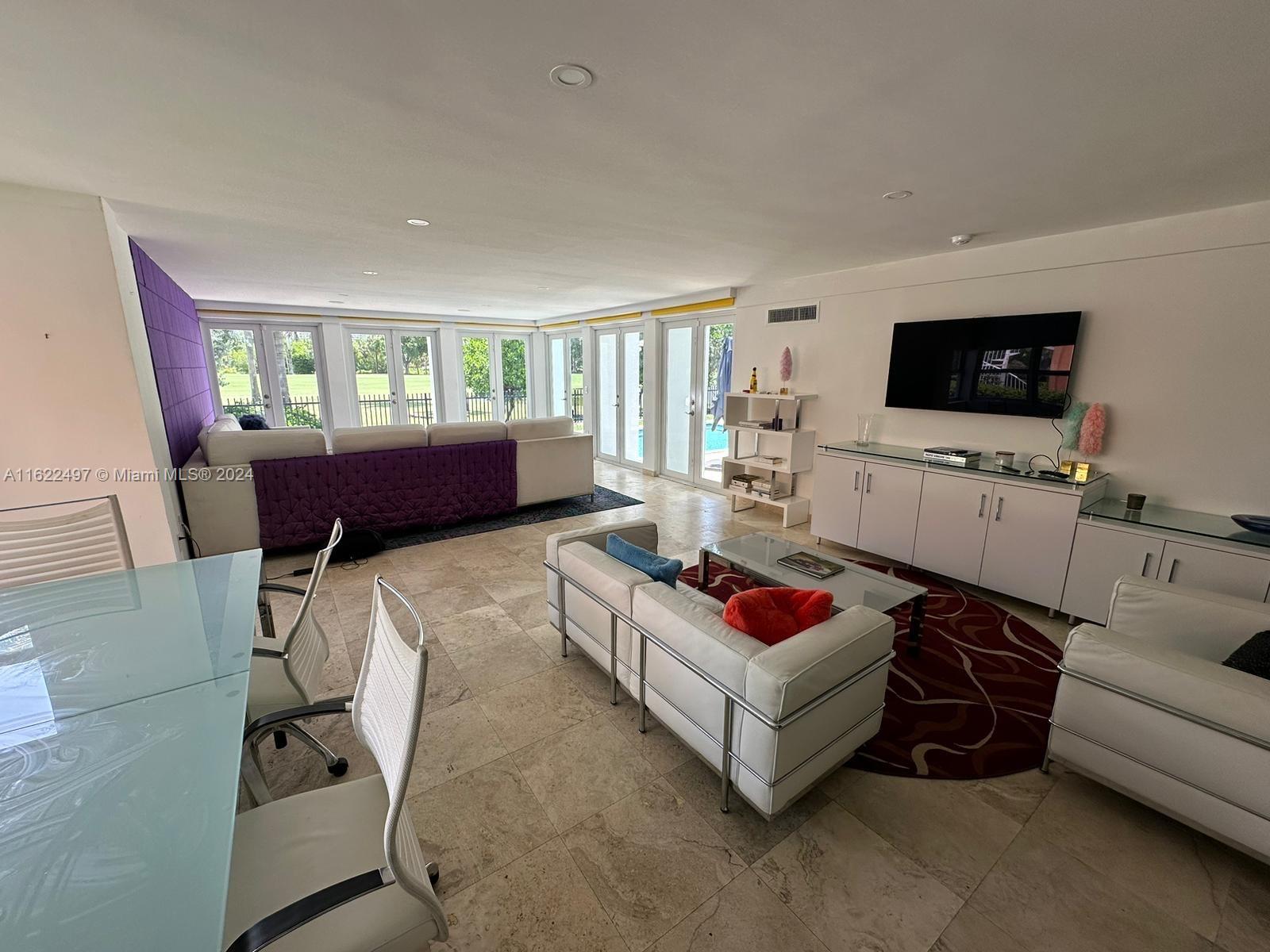 5301 Alton Road Miami Beach, FL 33140 - Photo 12 of 46 a living room with furniture and a flat screen tv