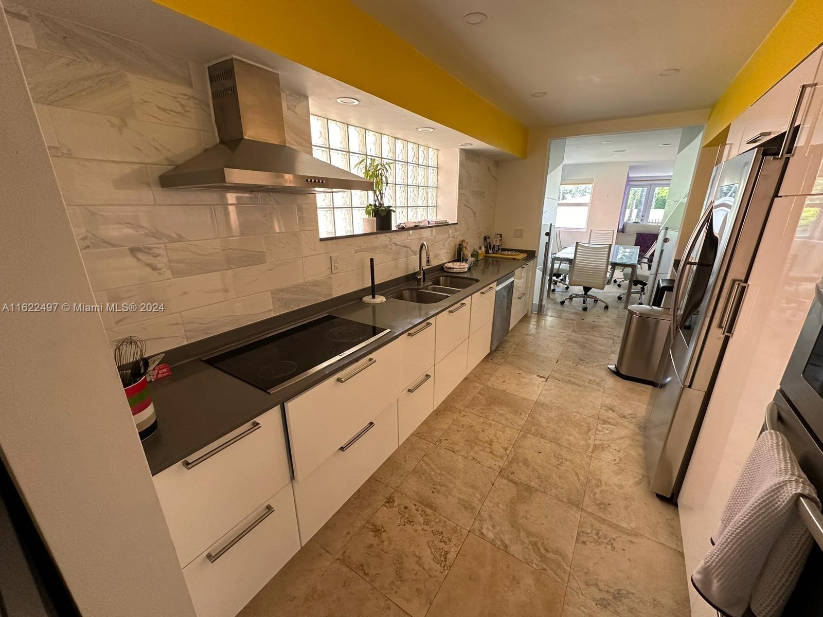 5301 Alton Road Miami Beach, FL 33140 - Photo 14 of 46 a large white kitchen with sink refrigerator and window
