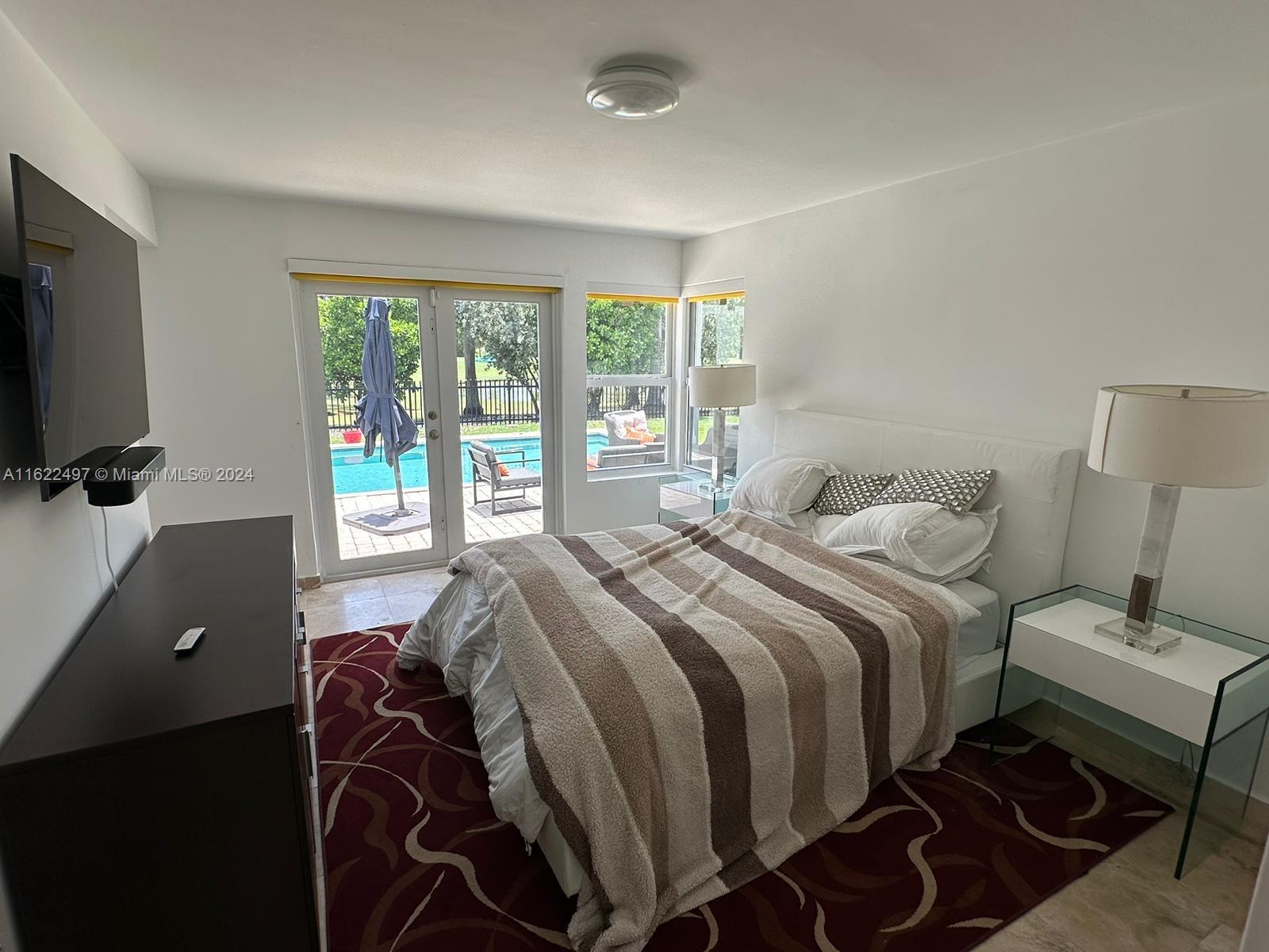 5301 Alton Road Miami Beach, FL 33140 - Photo 22 of 46 a bedroom with a bed and a flat screen tv