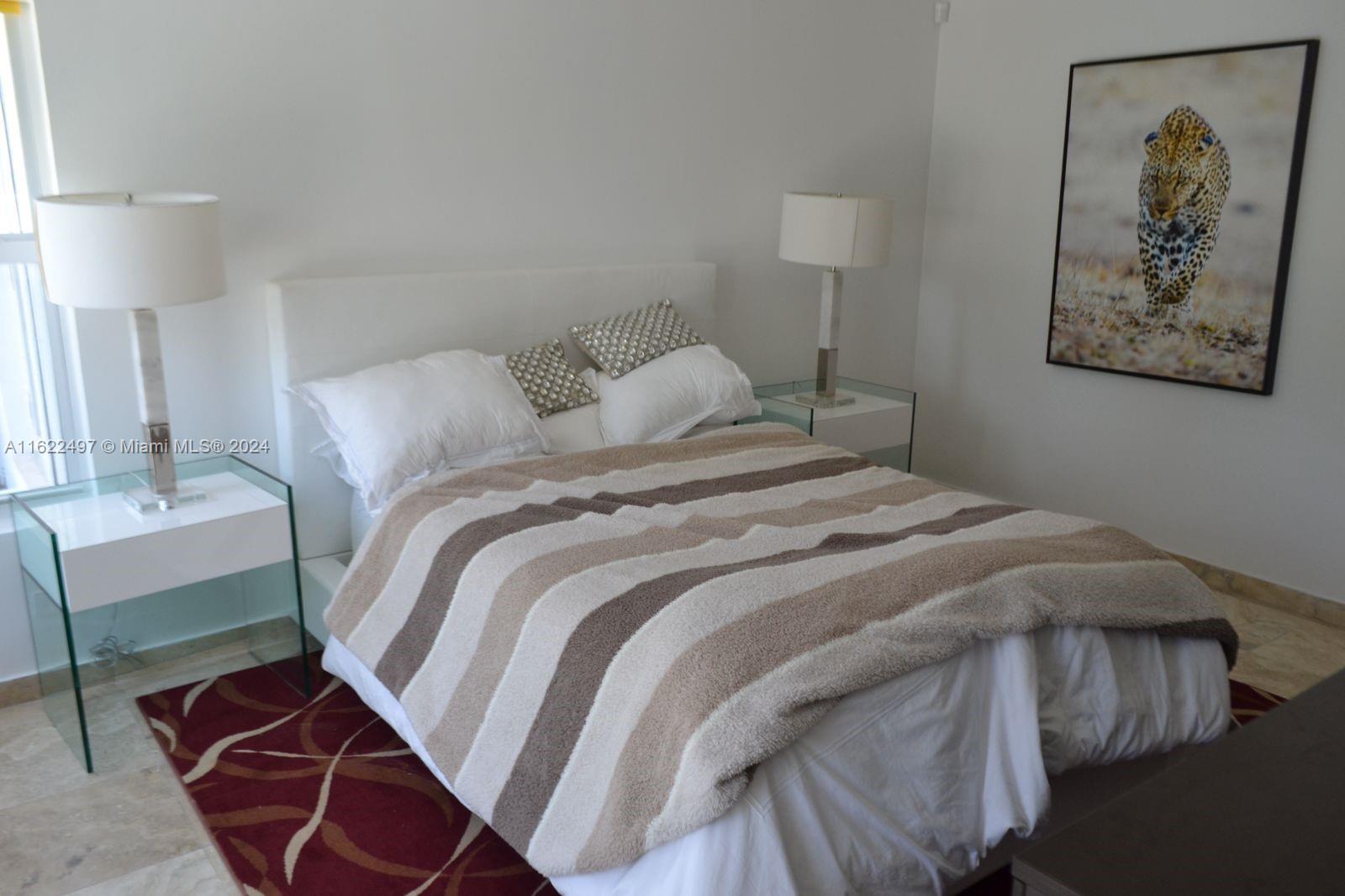 5301 Alton Road Miami Beach, FL 33140 - Photo 23 of 46 a bedroom with a bed and a lamp on table