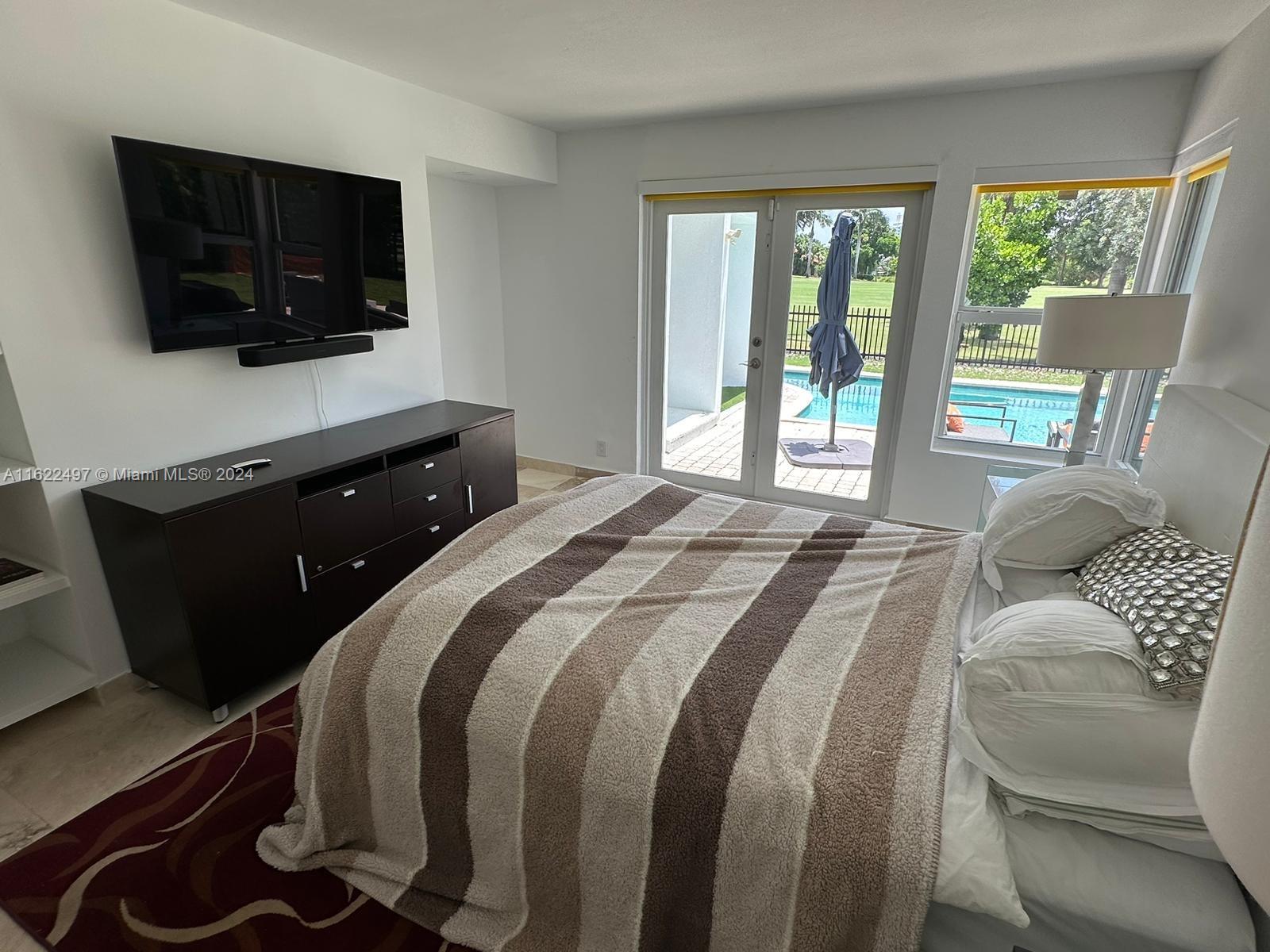 5301 Alton Road Miami Beach, FL 33140 - Photo 26 of 46 a bedroom with a bed and a flat screen tv