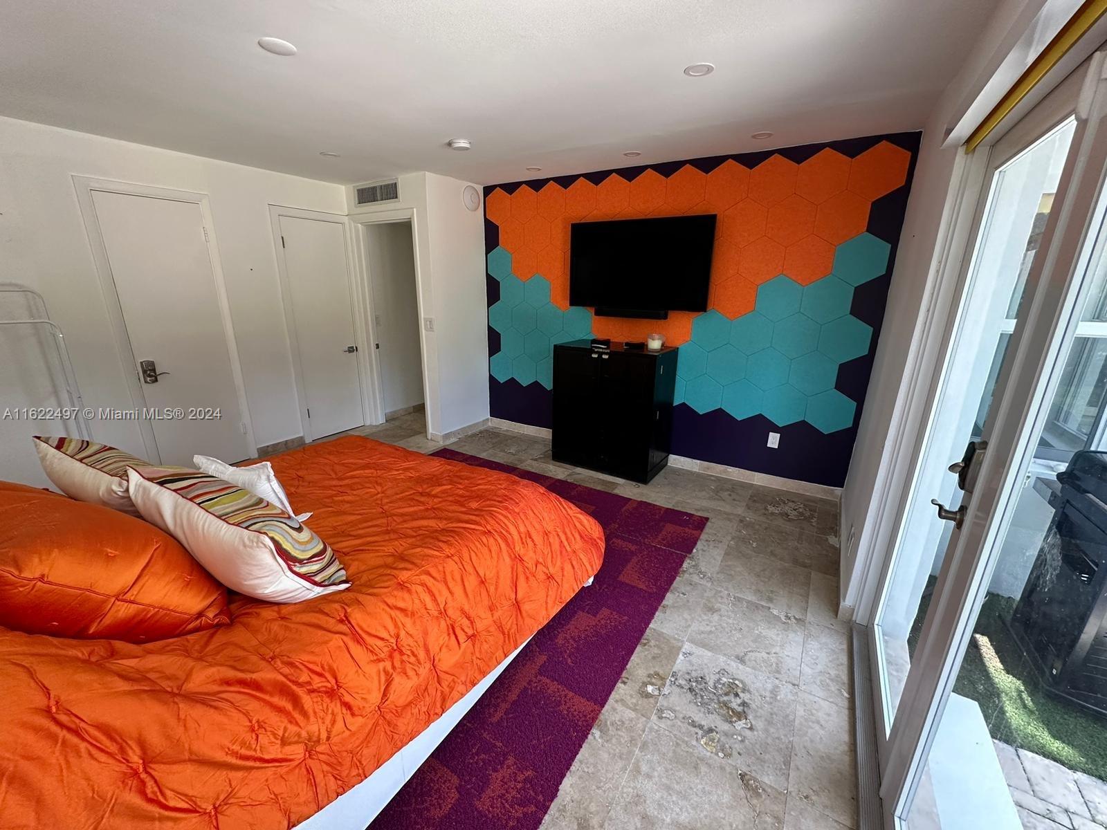 5301 Alton Road Miami Beach, FL 33140 - Photo 31 of 46 a bedroom with a bed and a flat screen tv