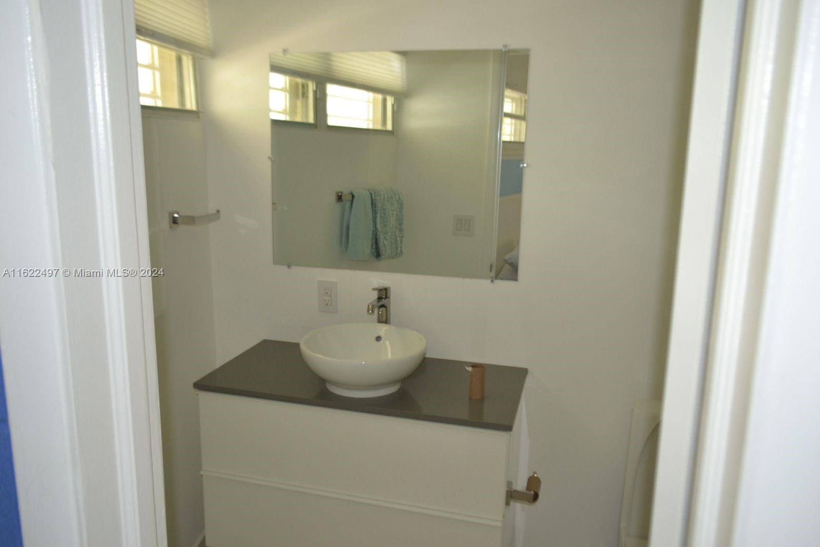 5301 Alton Road Miami Beach, FL 33140 - Photo 36 of 46 a bathroom with a sink and a mirror