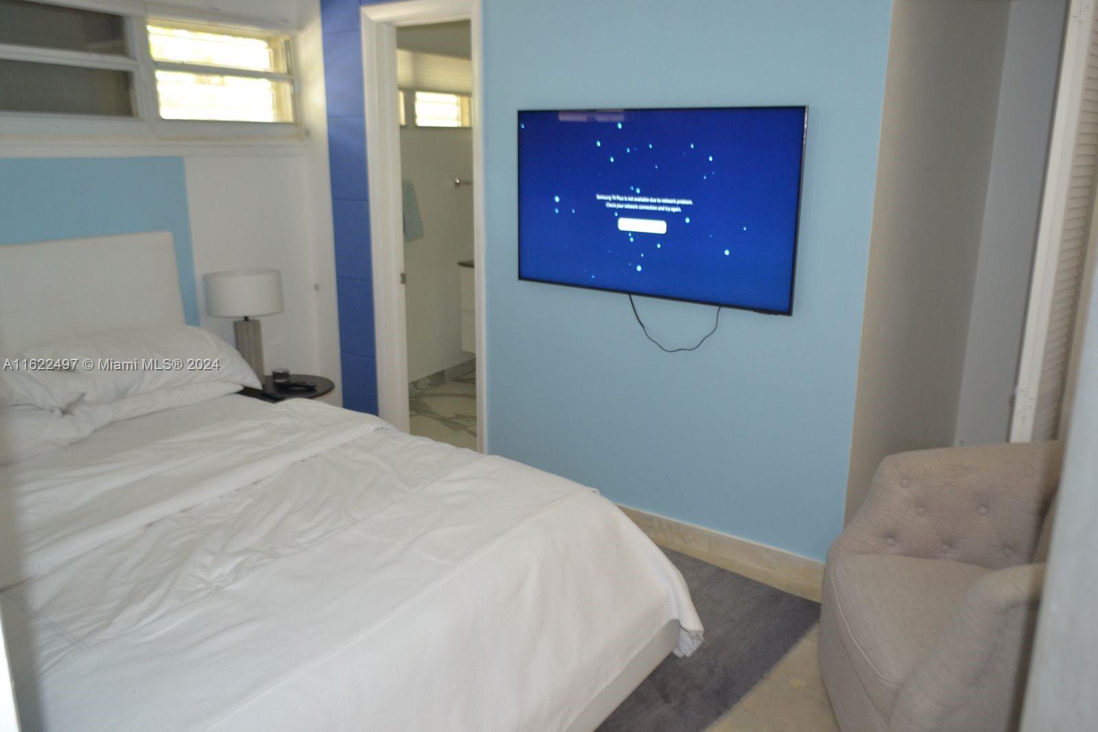 5301 Alton Road Miami Beach, FL 33140 - Photo 41 of 46 a bedroom with a bed and a painting on the wall