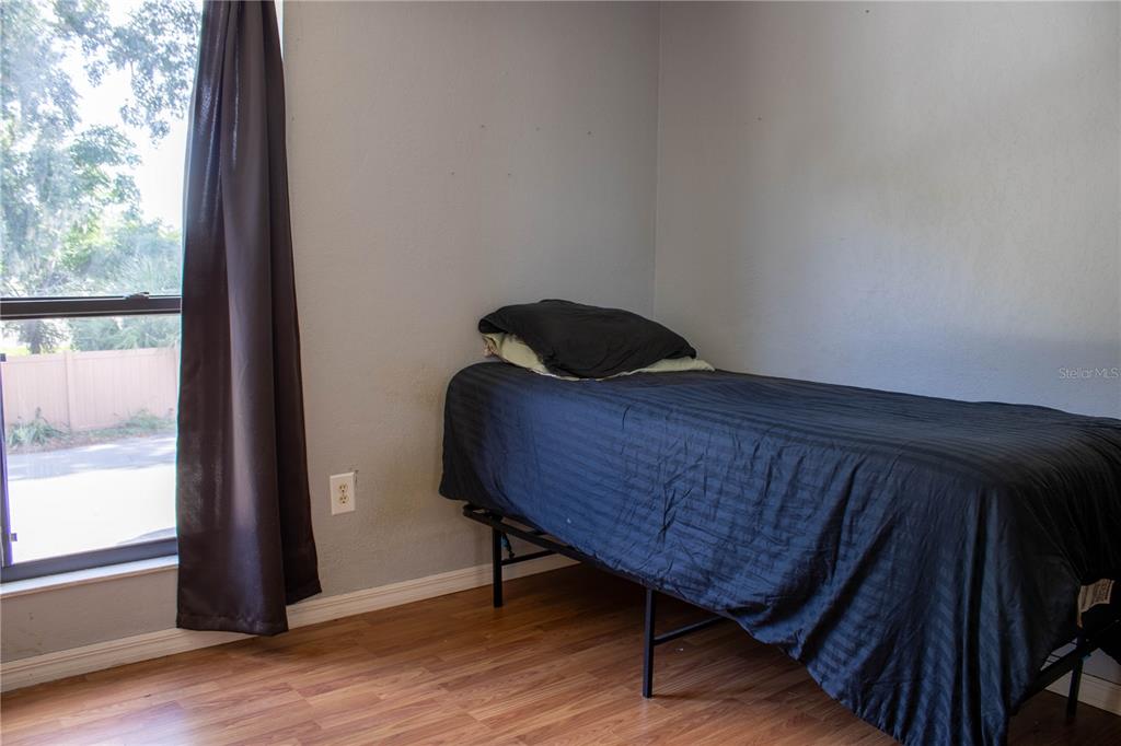 1836 North Crystal Lake Drive, Unit 95 Lakeland, FL 33801 - Photo 24 of 31 a bedroom with a bed and wooden floor