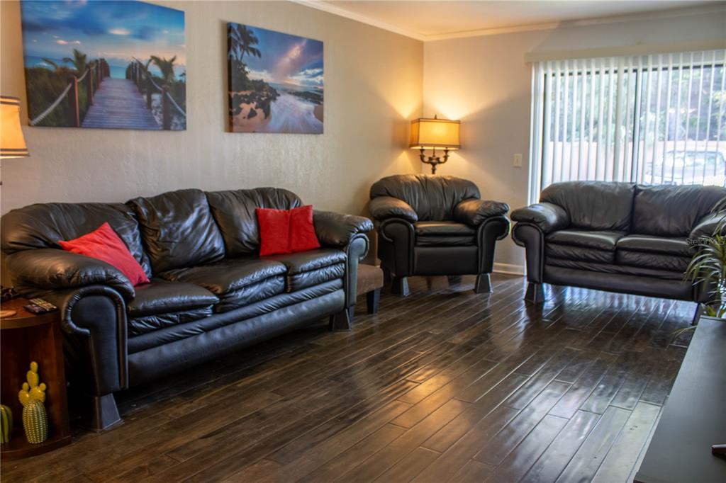 1836 North Crystal Lake Drive, Unit 95 Lakeland, FL 33801 - Photo 5 of 31 a living room with furniture and a wooden floor