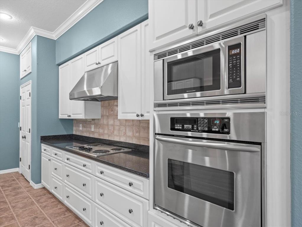 8698 Mississippi Run Weeki Wachee, FL 34613 - Photo 25 of 58 a kitchen with stainless steel appliances white cabinets and stove