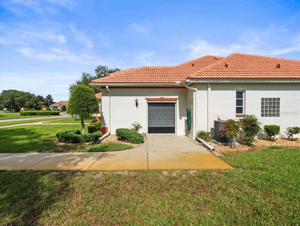8698 Mississippi Run Weeki Wachee, FL 34613 - Photo 3 of 58 a front view of a house with a yard and garage