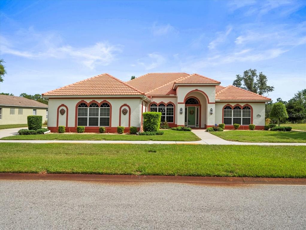 8698 Mississippi Run Weeki Wachee, FL 34613 - Photo 5 of 58 a front view of a house with a garden and yard