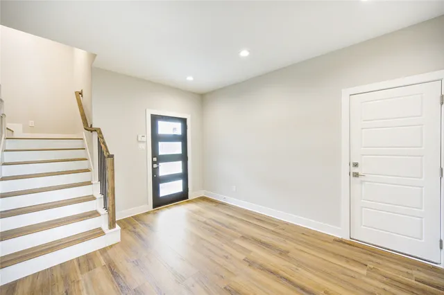 a view of empty room with wooden floor and white walls