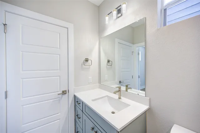 a bathroom with a sink toilet and mirror