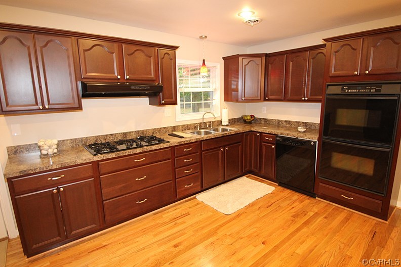 12010 West Petty Road Midlothian, VA 23113 - Photo 4 of 20 a kitchen with stainless steel appliances granite countertop wooden cabinets and a stove top oven