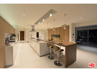 1645 Carla Ridge Beverly Hills, CA 90210 - Photo 6 of 26 a living room with stainless steel appliances kitchen island a table chairs and a refrigerator