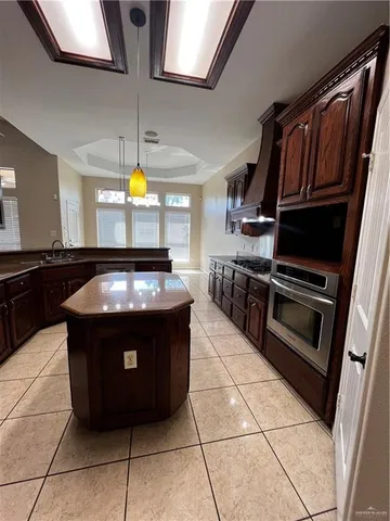 a kitchen with stainless steel appliances granite countertop a stove a sink and a microwave