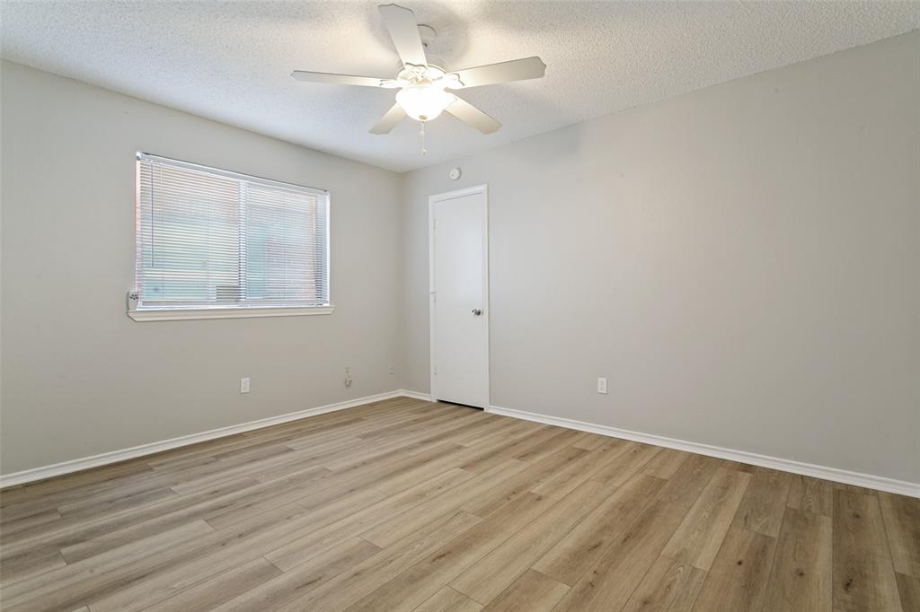 1712 East Peters Colony Road Carrollton, TX 75007 - Photo 17 of 25 Room featuring light wood-finish flooring, light gray walls, a white ceiling fan, and a single window with blinds