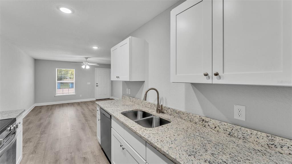 502 2nd Street Southwest Fort Meade, FL 33841 - Photo 25 of 39 a kitchen with granite countertop a sink a stove and cabinets