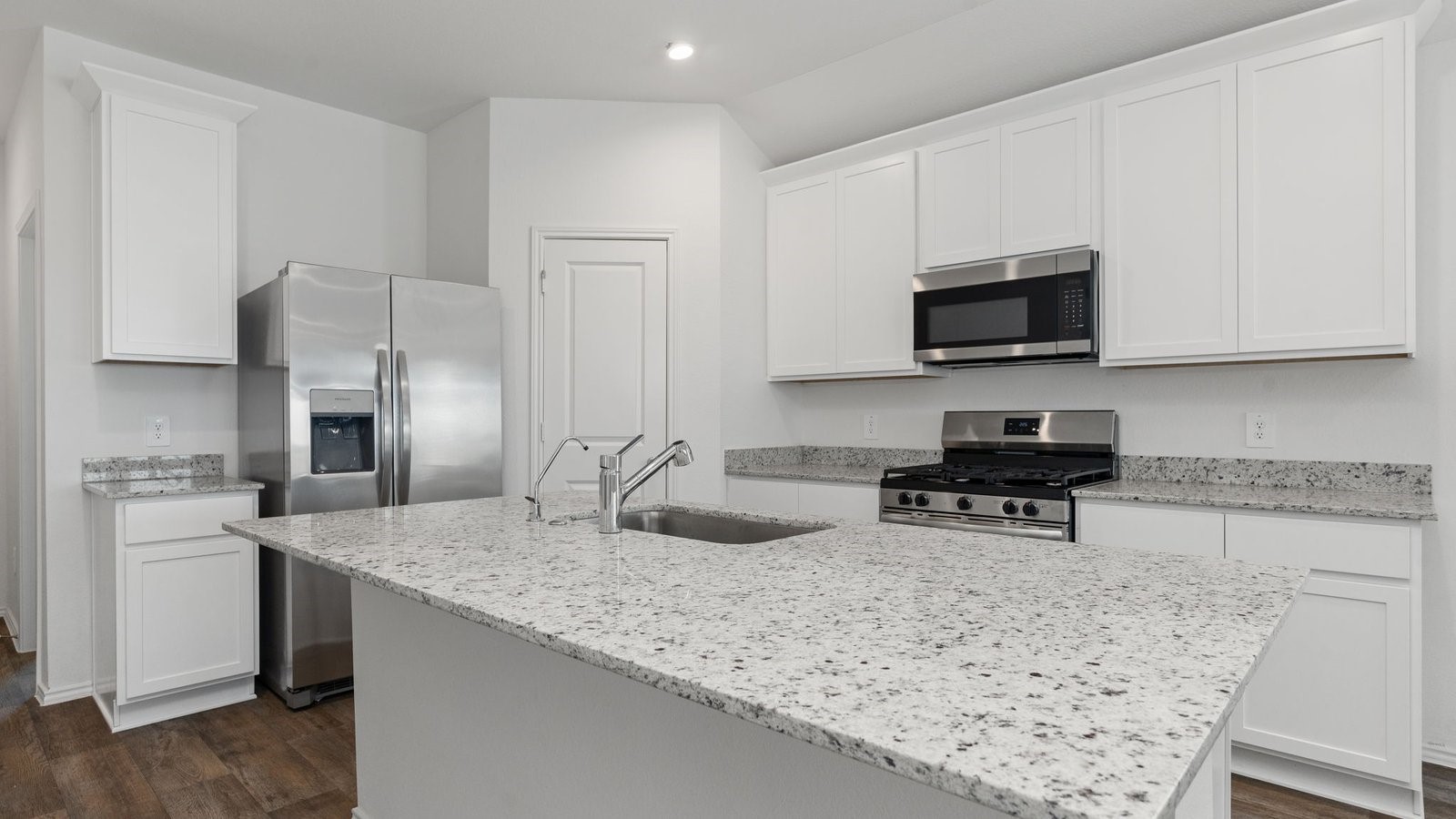 3623 Koop Loop Fulshear, TX 77423 - Photo 11 of 47 a kitchen with stainless steel appliances granite countertop a sink stove and microwave