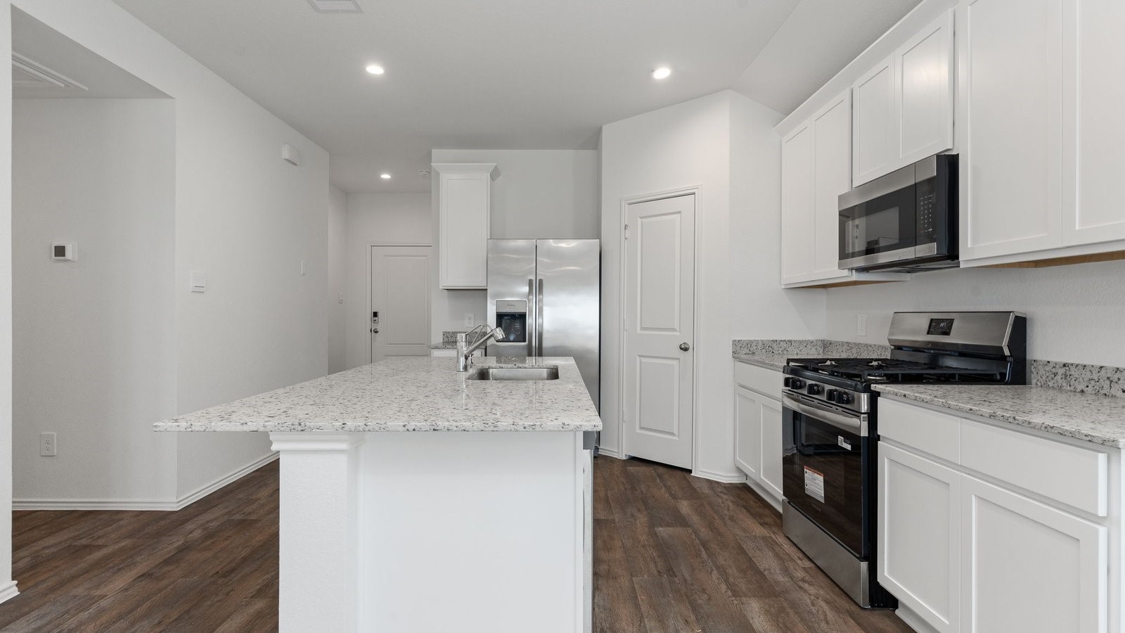 3623 Koop Loop Fulshear, TX 77423 - Photo 12 of 47 a kitchen with stainless steel appliances granite countertop a sink stove and microwave