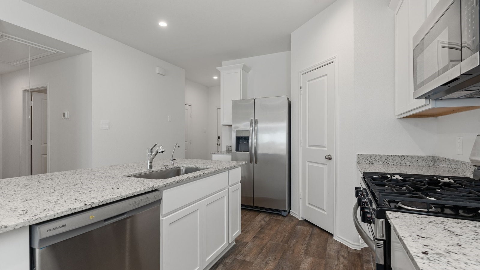 3623 Koop Loop Fulshear, TX 77423 - Photo 13 of 47 a kitchen with stainless steel appliances granite countertop a sink stove and refrigerator