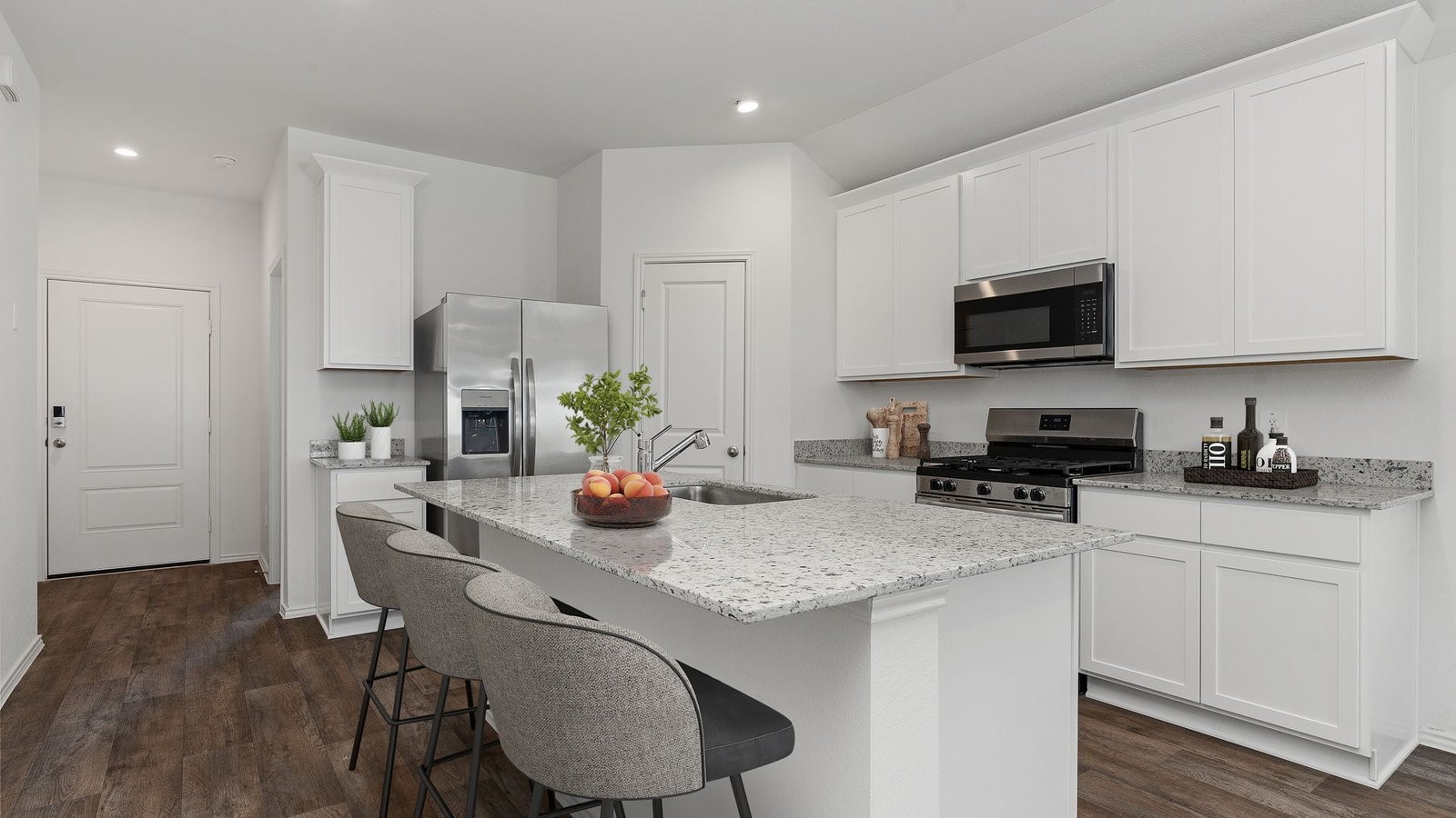 3623 Koop Loop Fulshear, TX 77423 - Photo 10 of 47 a kitchen with stainless steel appliances granite countertop a stove a sink a microwave a refrigerator and white cabinets with wooden floor