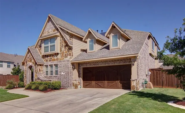 a front view of a house with a garden and yard