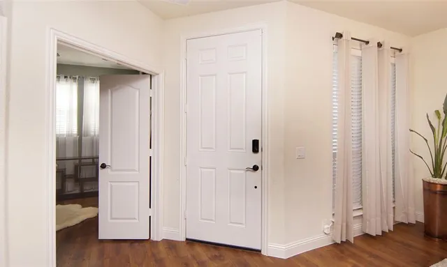 a view of a bathroom with a walk in closet and wooden floor