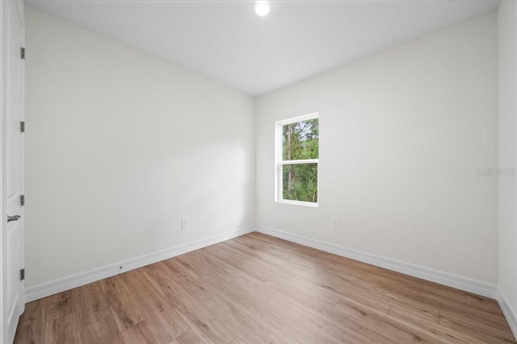 2643 Rushmore Street North Port, FL 34288 - Photo 22 of 25 an empty room with wooden floor and windows