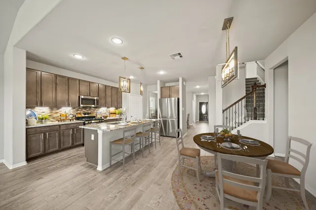 a view of a livingroom with a fireplace a ceiling fan and windows