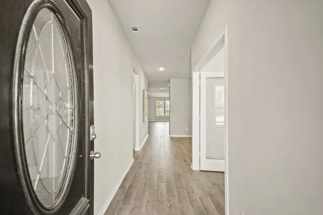a view of a hallway with wooden floor