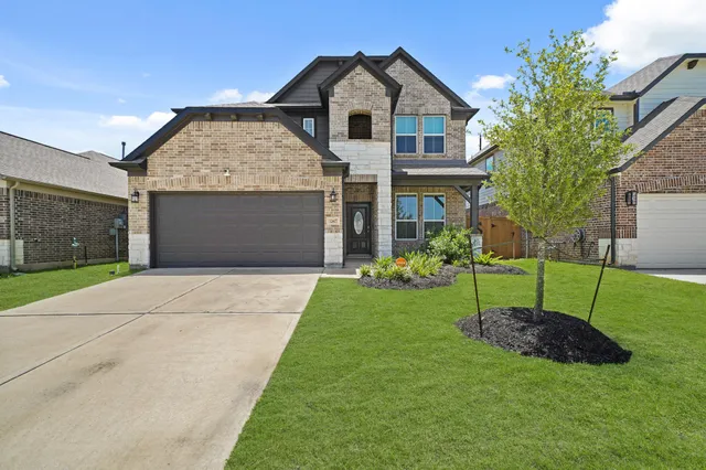a front view of a house with a yard and garage