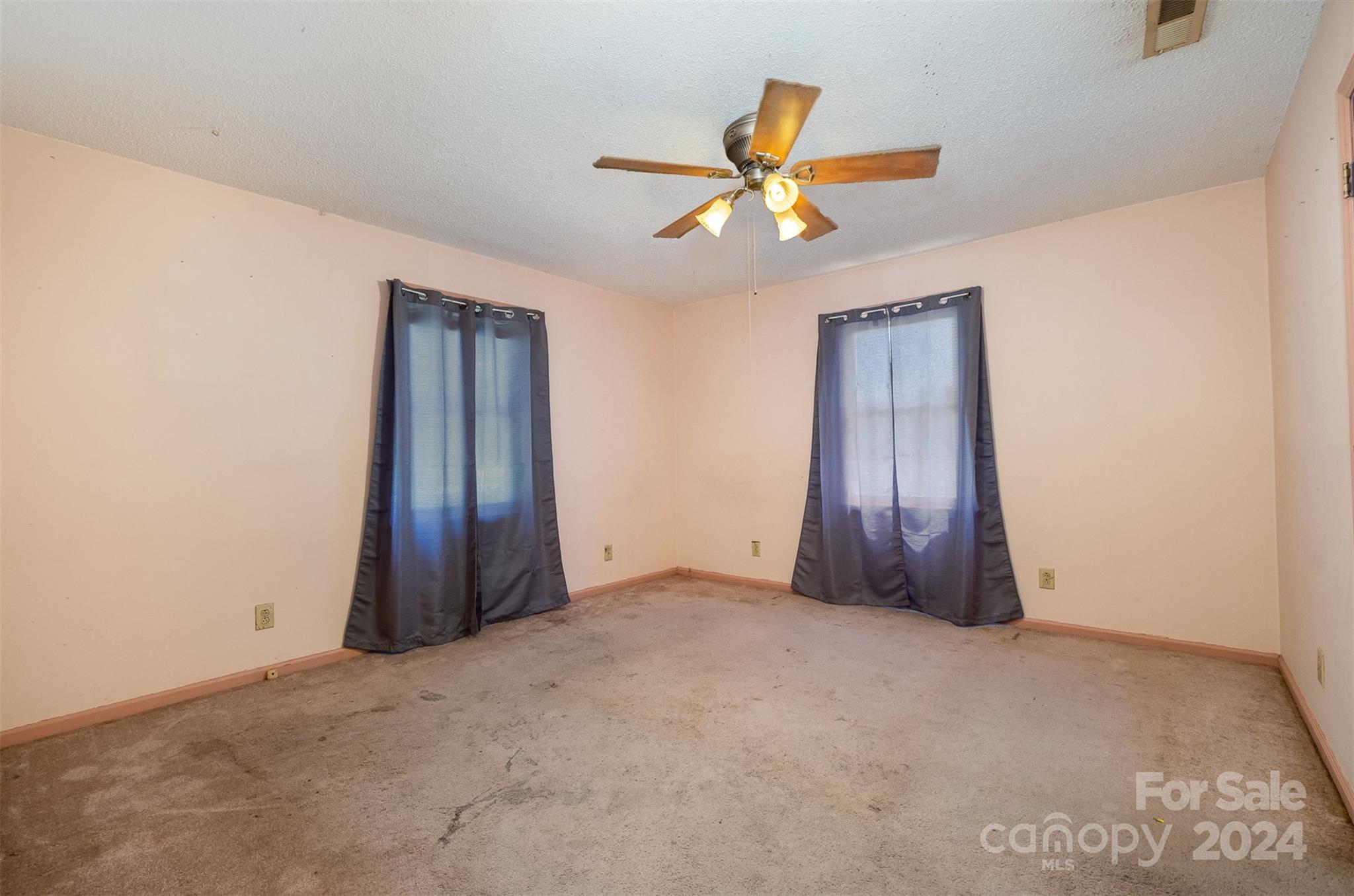6907 St Timothy Road Marshville, NC 28103 - Photo 11 of 21 an empty room with a chandelier fan and windows