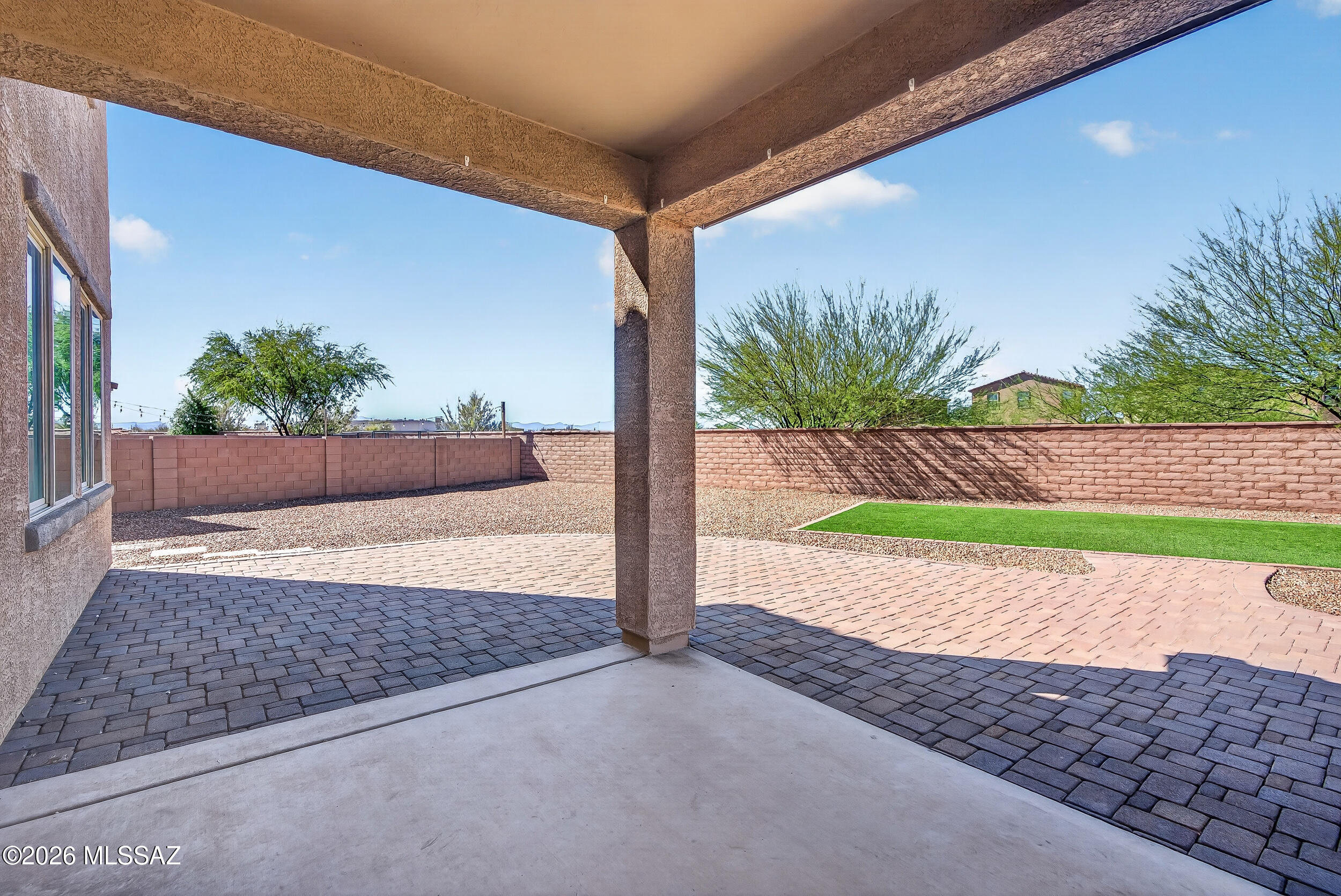 7556 South Circulo Rio Blanco Tucson, AZ 85756 - Photo 35 of 50 Inviting covered patio with extended paver seating area — perfect for outdoor dining, relaxing, or entertaining under the Arizona sky.
