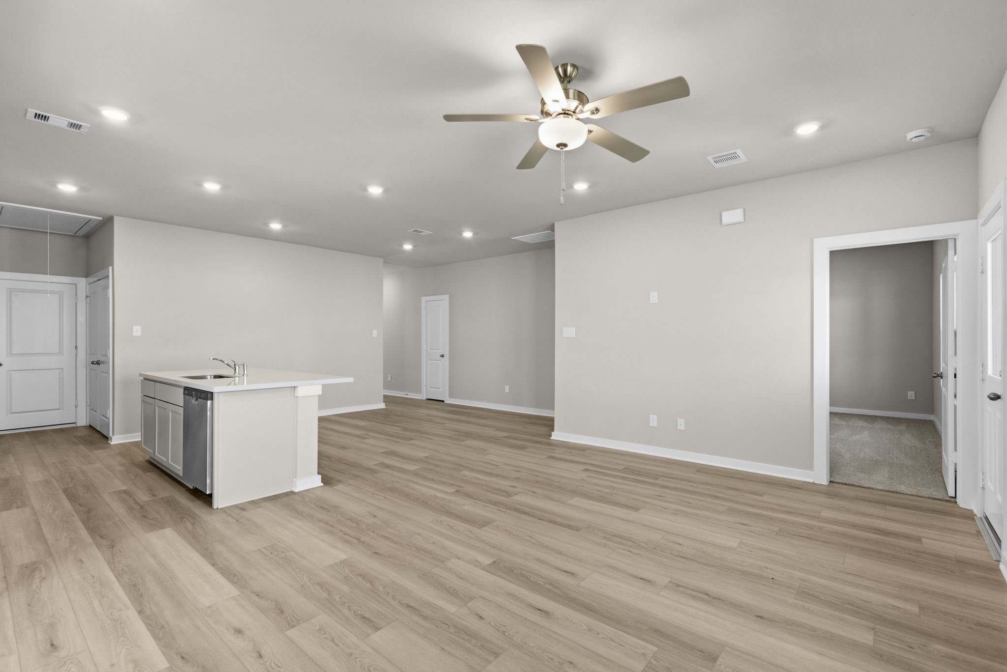 3627 Atlas Pt Lane Angleton, TX 77515 - Photo 12 of 36 an empty room with wooden floor and kitchen view