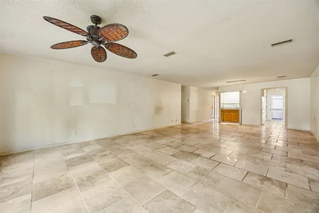 an empty room with a ceiling fan and a window