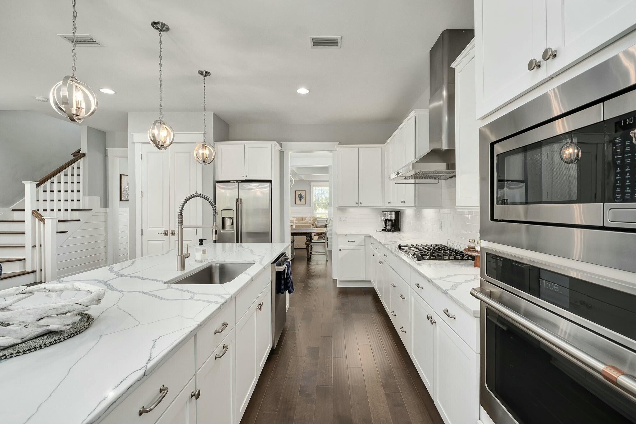 116 Prairie Pass Santa Rosa Beach, FL 32459 - Photo 12 of 59 a large kitchen with white cabinets and stainless steel appliances