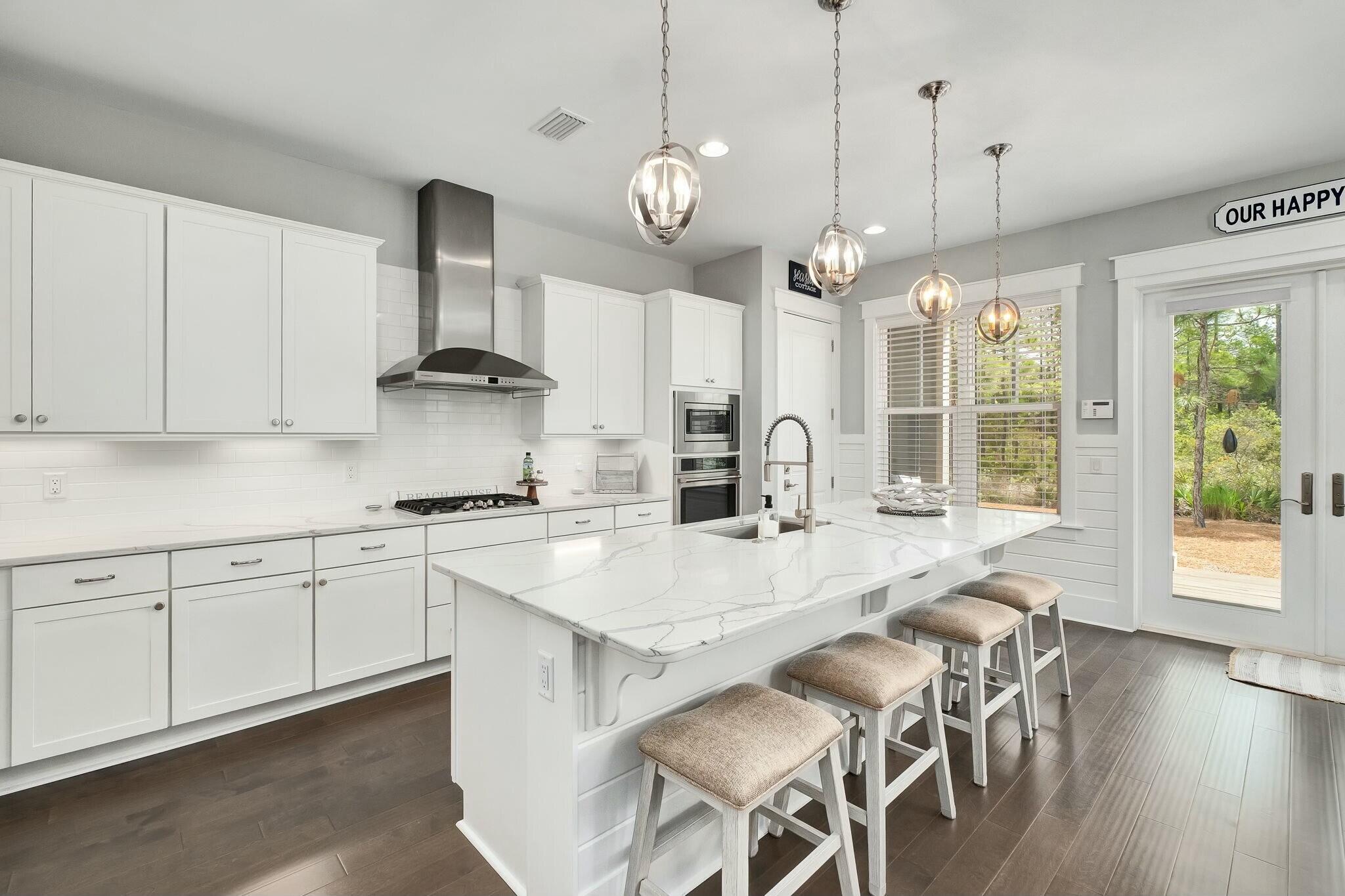 116 Prairie Pass Santa Rosa Beach, FL 32459 - Photo 13 of 59 a kitchen with stainless steel appliances granite countertop a stove a sink a refrigerator a stove a dining table and chairs with wooden floor