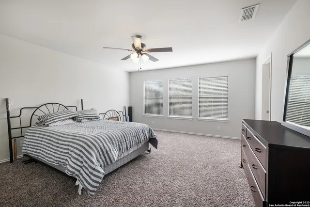 a bedroom with a bed a window and a flat screen television