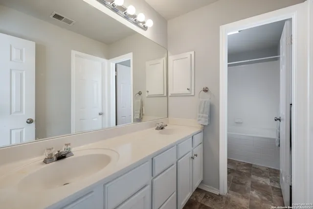 a bathroom with a sink double vanity and a mirror